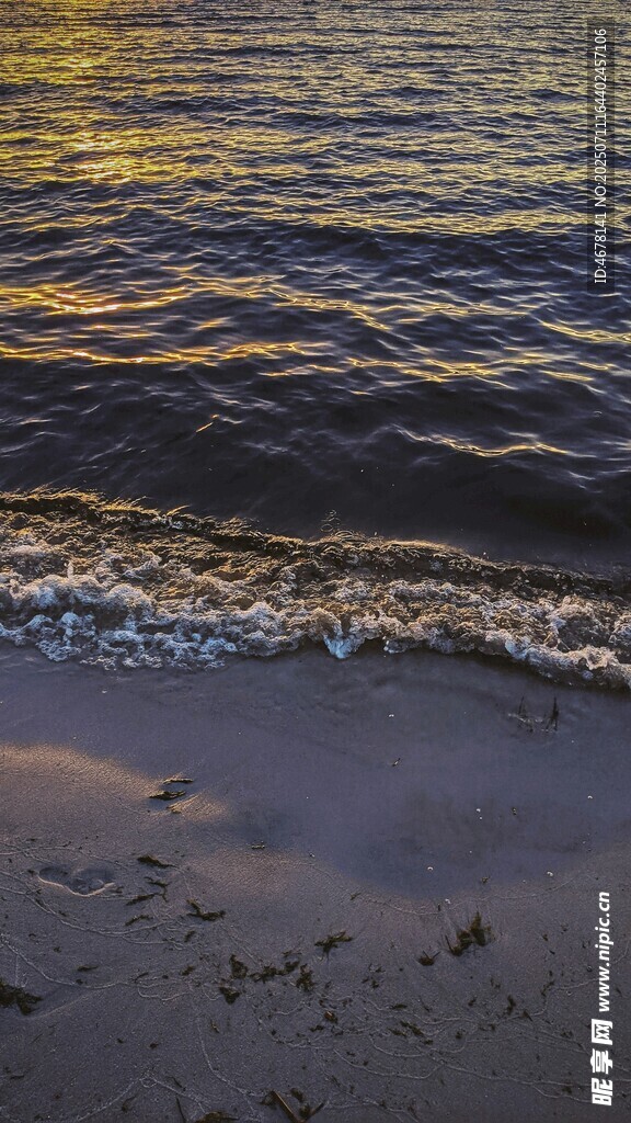 海边夕阳下的海浪沙滩
