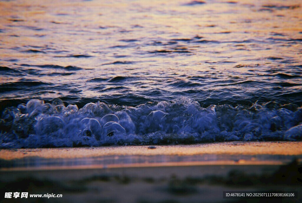 夕阳下的海浪拍打沙滩
