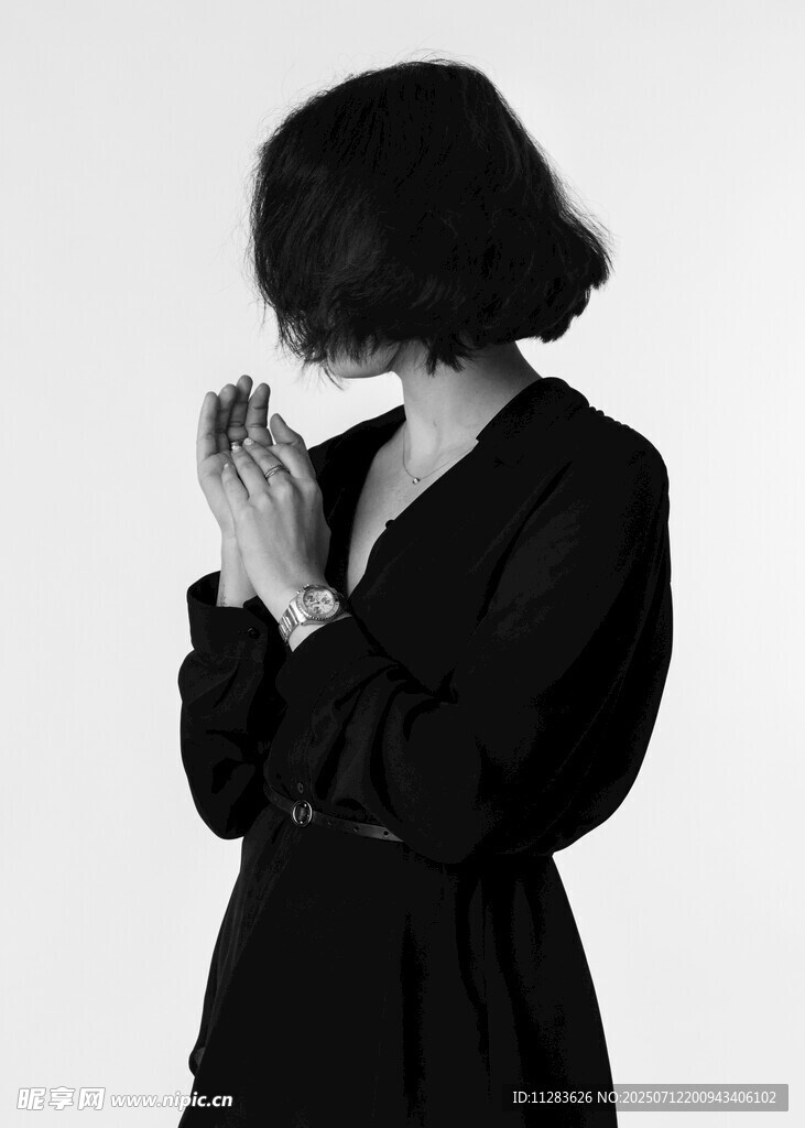 黑衣女子双手合十祈祷