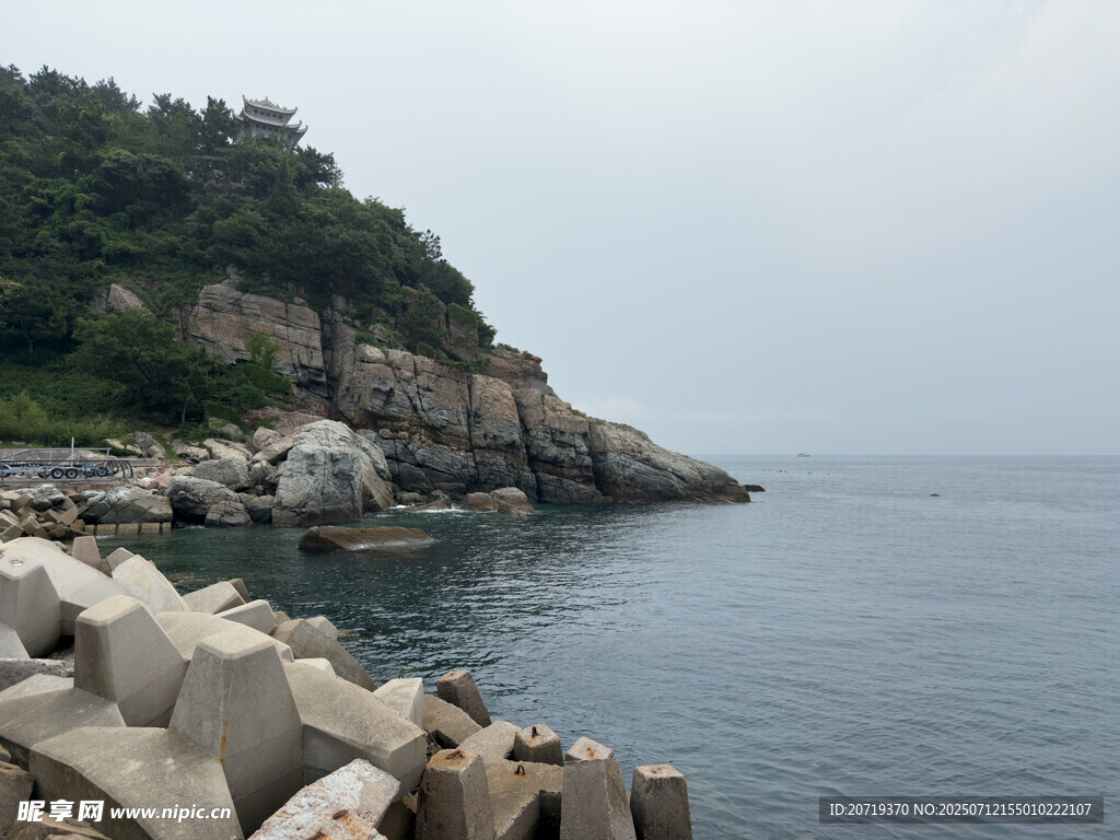海边石岸与葱郁山峦景色