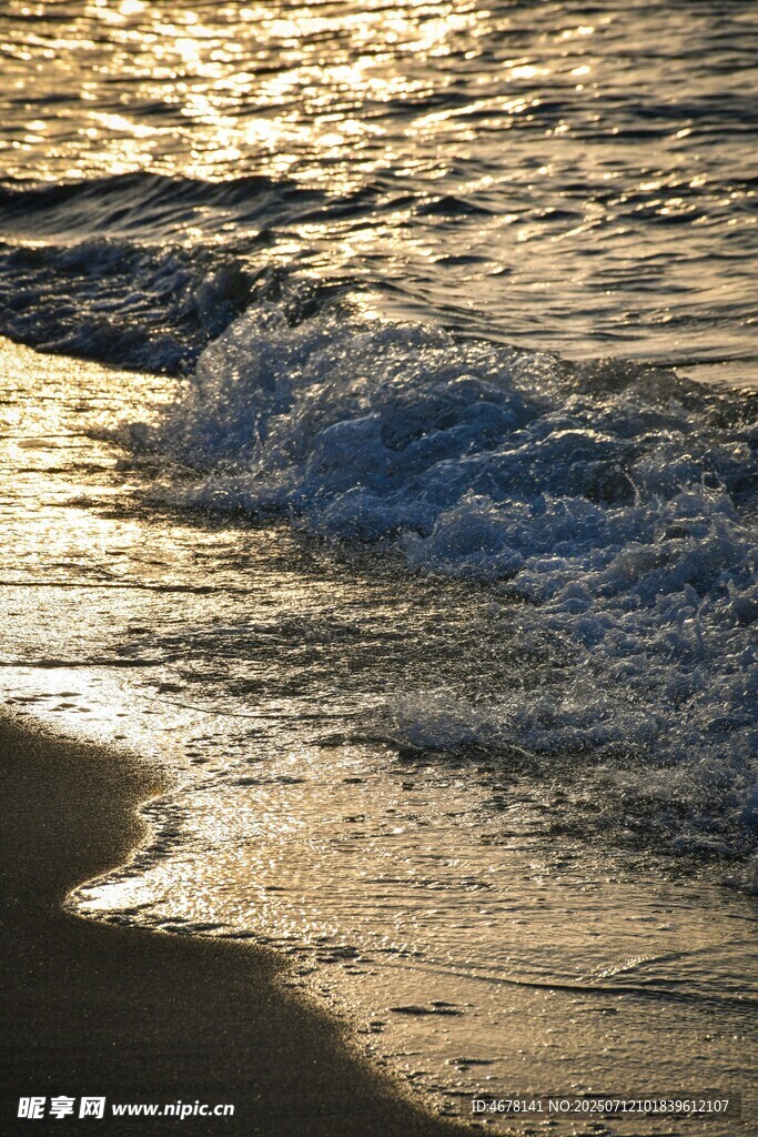 夕阳下的海浪拍打沙滩