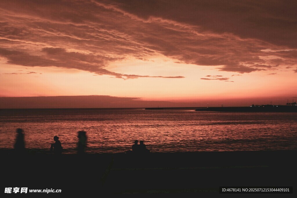 夕阳下的海边漫步身影
