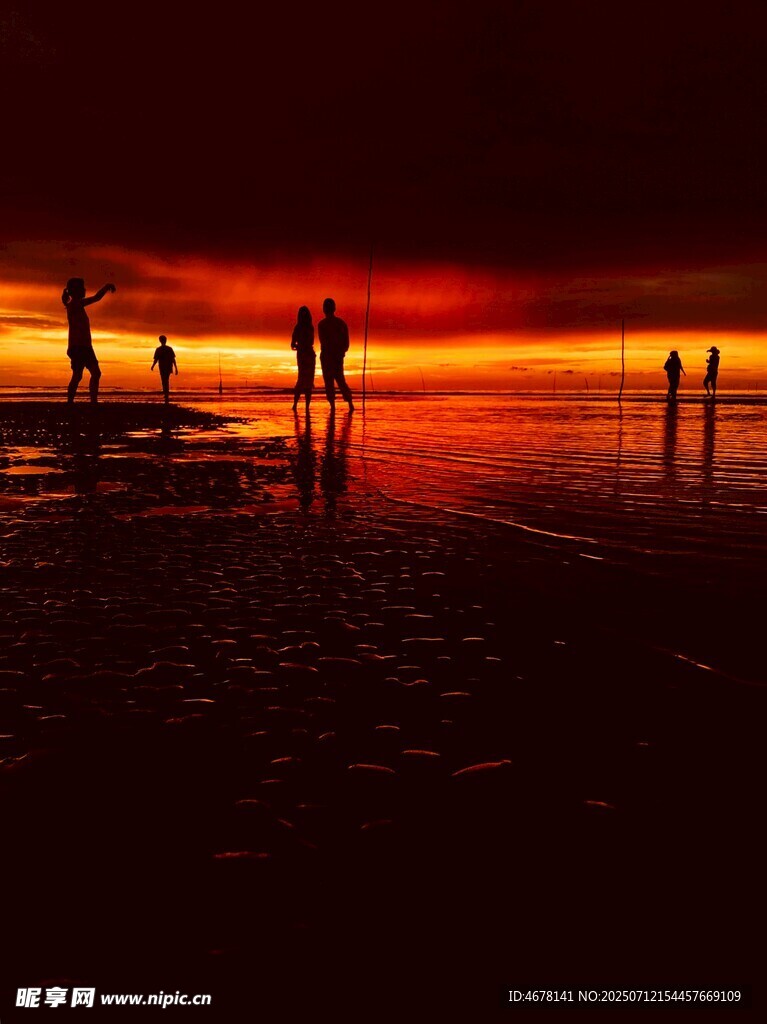 夕阳下海滩上的人影