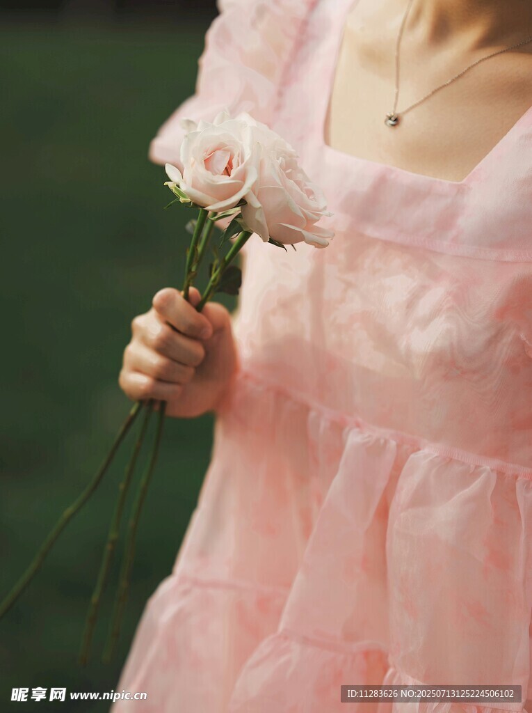 粉色裙装女子手持玫瑰花