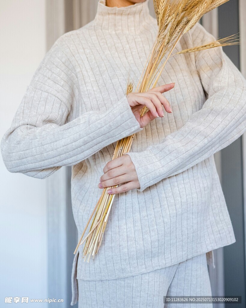 女子手持干草穿针织毛衣