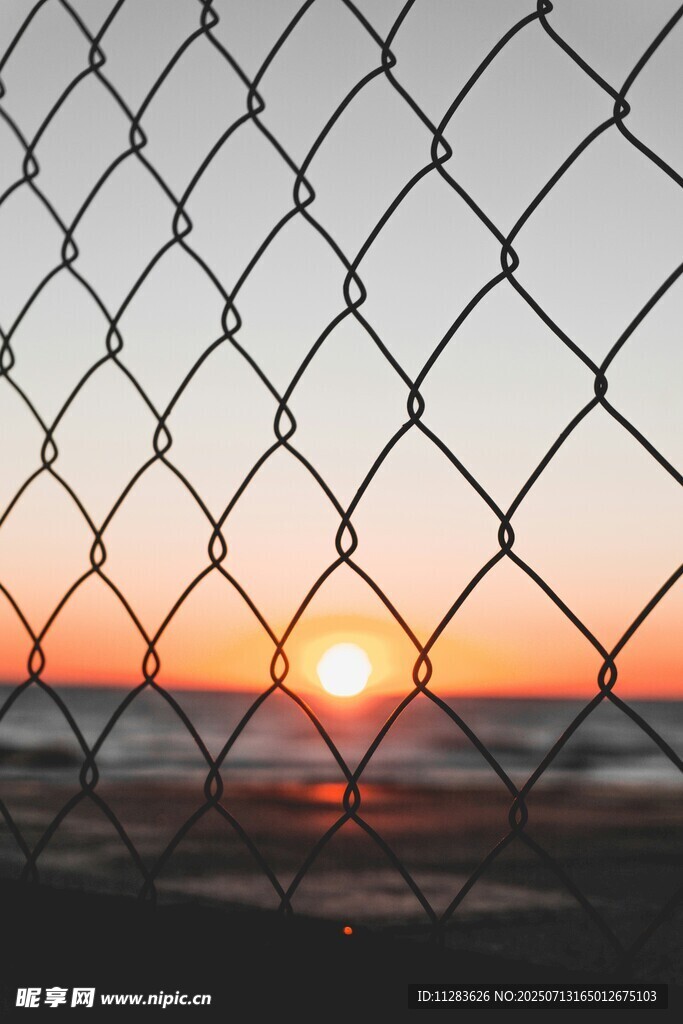 夕阳透过围栏洒向海面