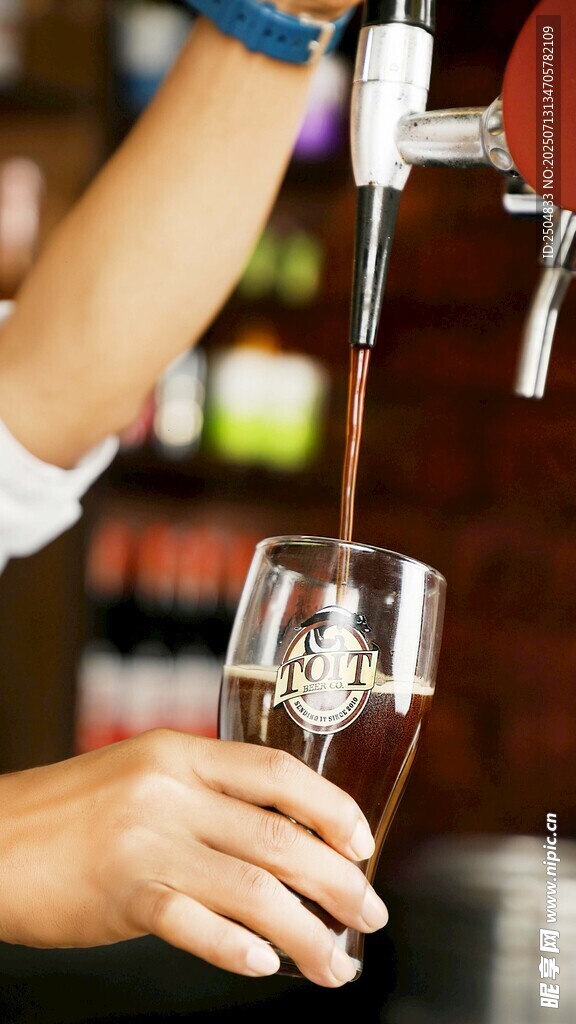 手从酒头往杯倒鲜啤酒