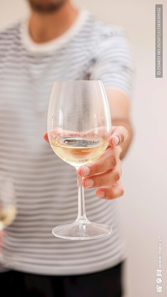 手持白葡萄酒杯的人