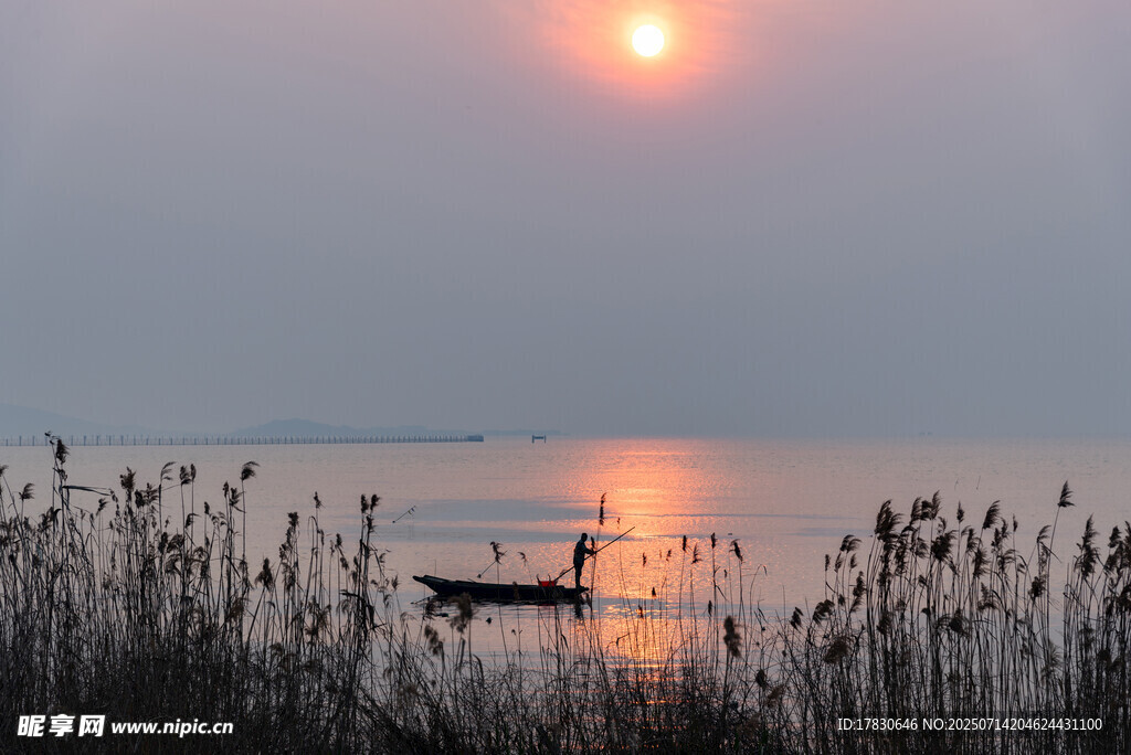 夕阳下湖面小船静谧景象