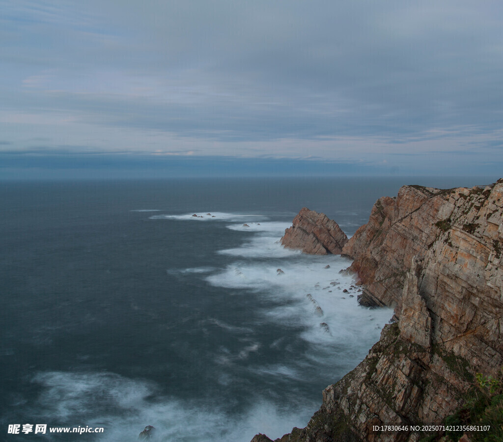 海岸边嶙峋岩石与翻涌海浪