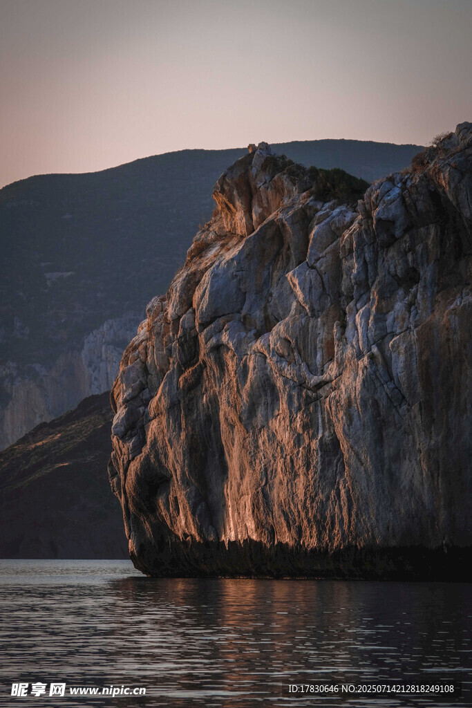 夕阳下的海边孤岩