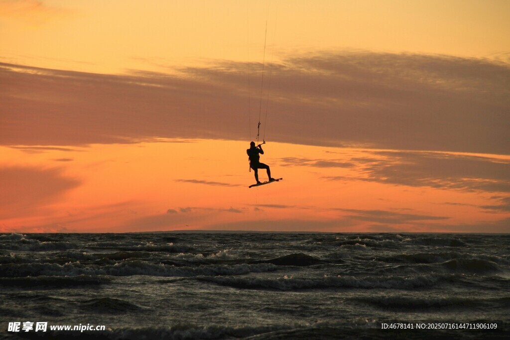 夕阳下的海上风筝冲浪者