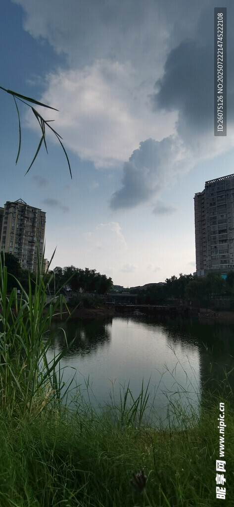 灰暗天空下的湖畔高楼与葱郁景致
