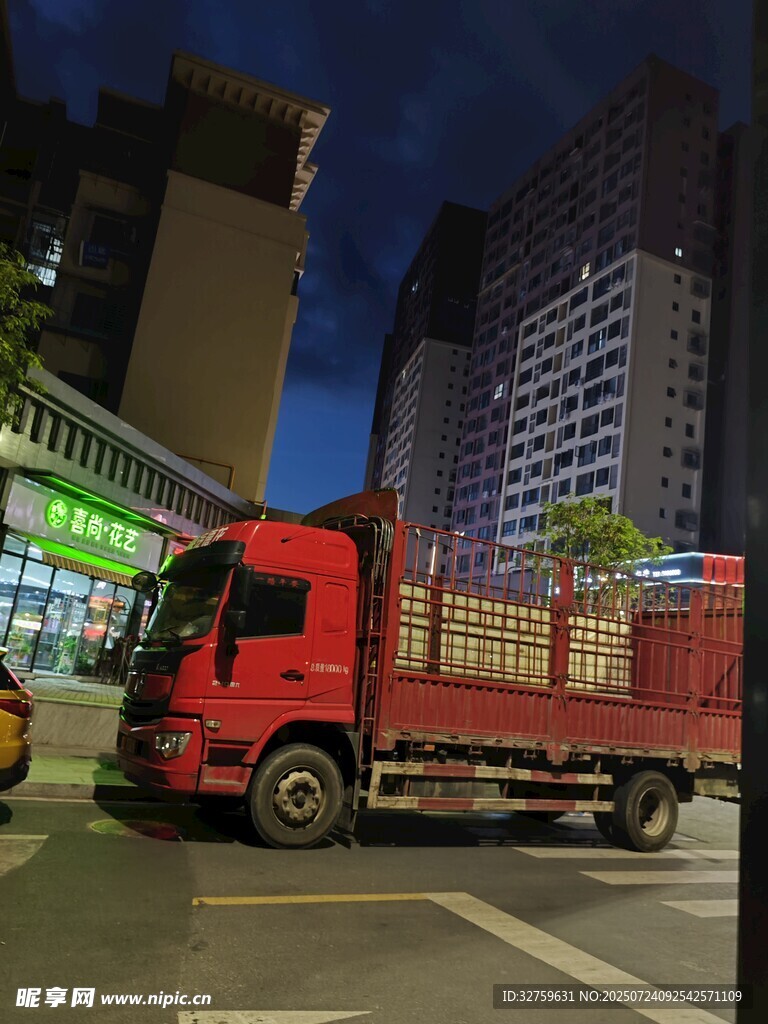 夜晚城市中的红色载货卡车