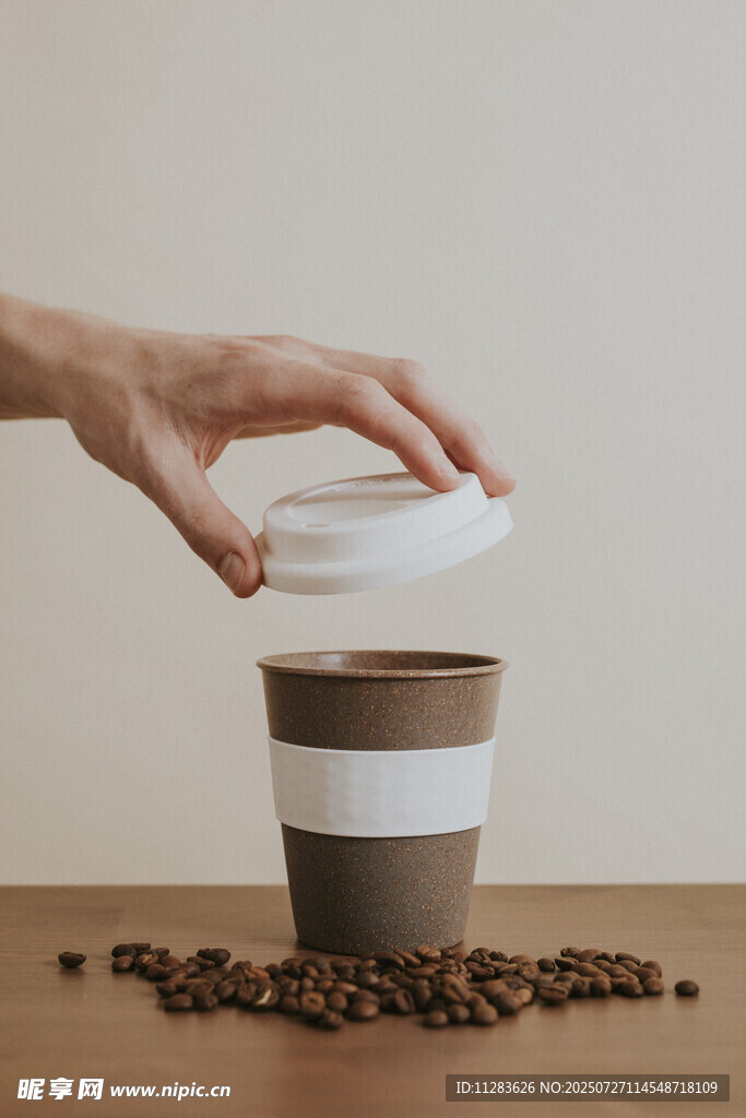 手盖咖啡杯和散落咖啡豆
