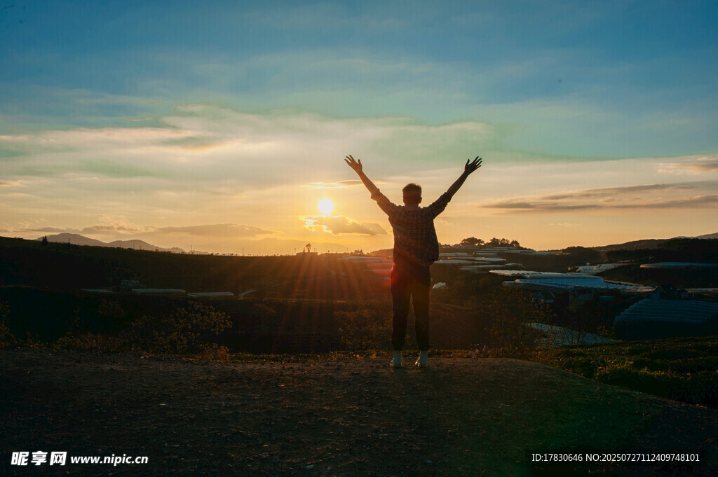 夕阳下张开双臂的人影