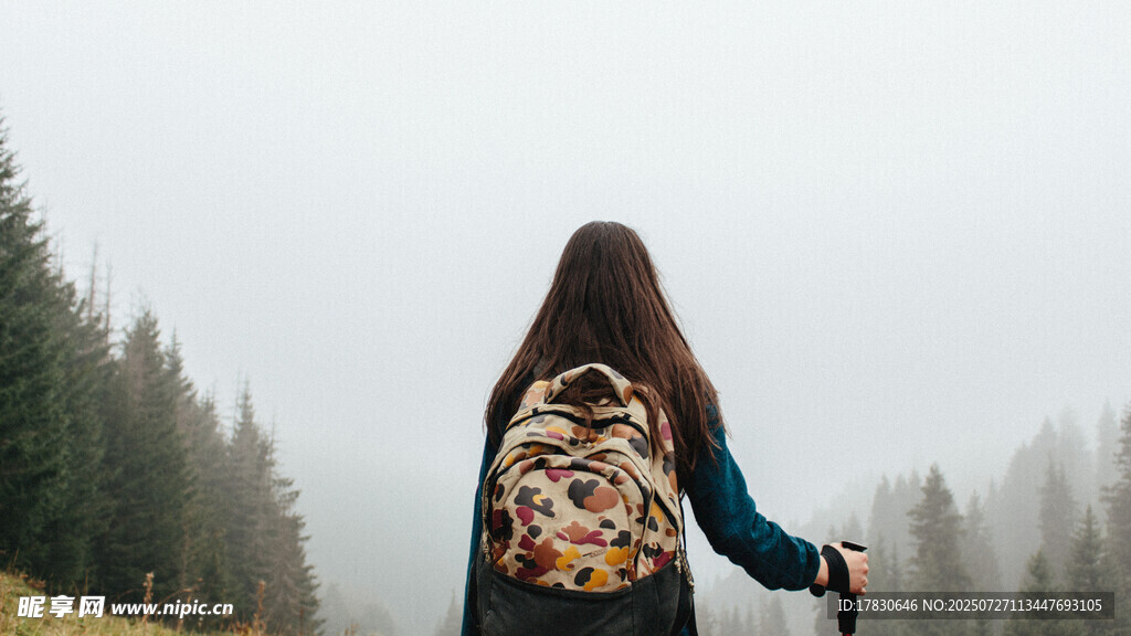 女孩背背包漫步山林间