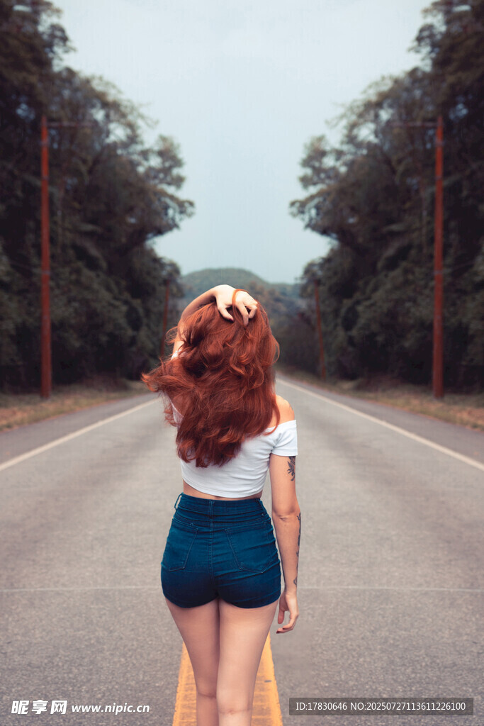 红发女孩独行于林荫道路