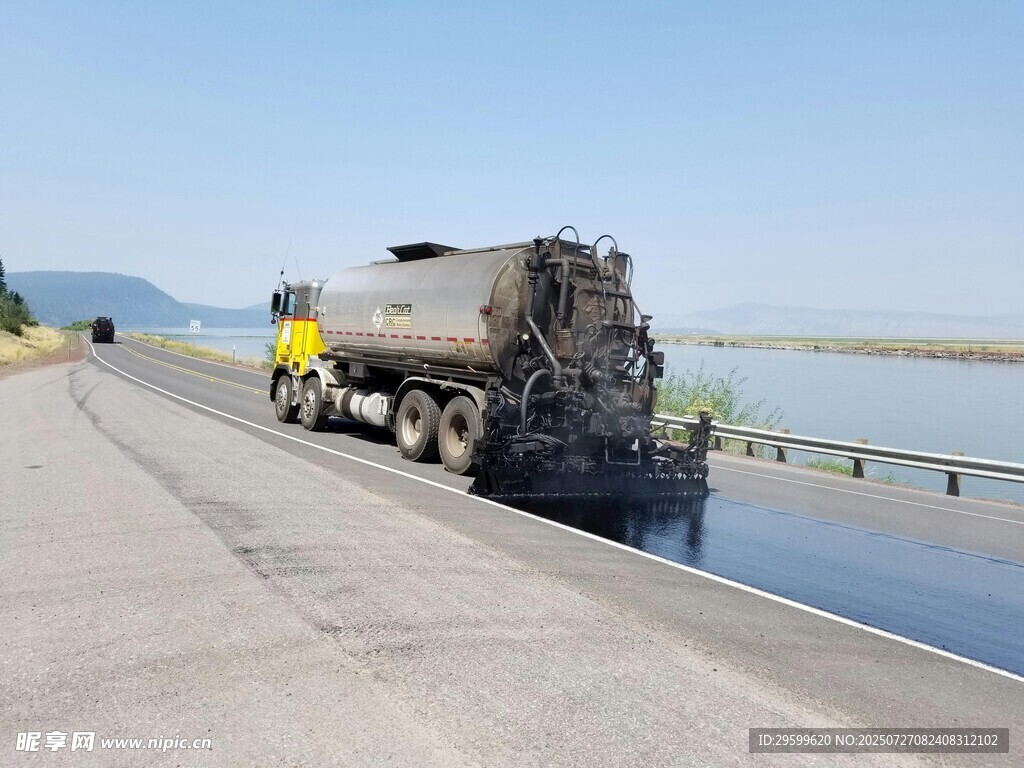 公路上的油罐车与水域景观