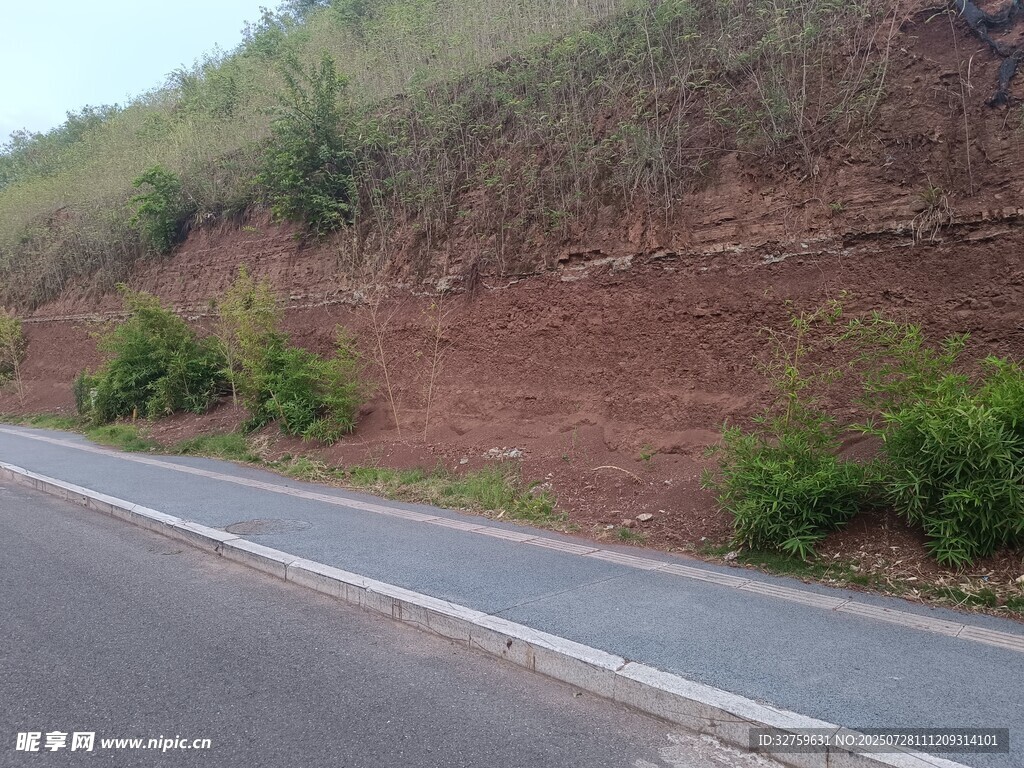 蜿蜒公路旁的红土山坡