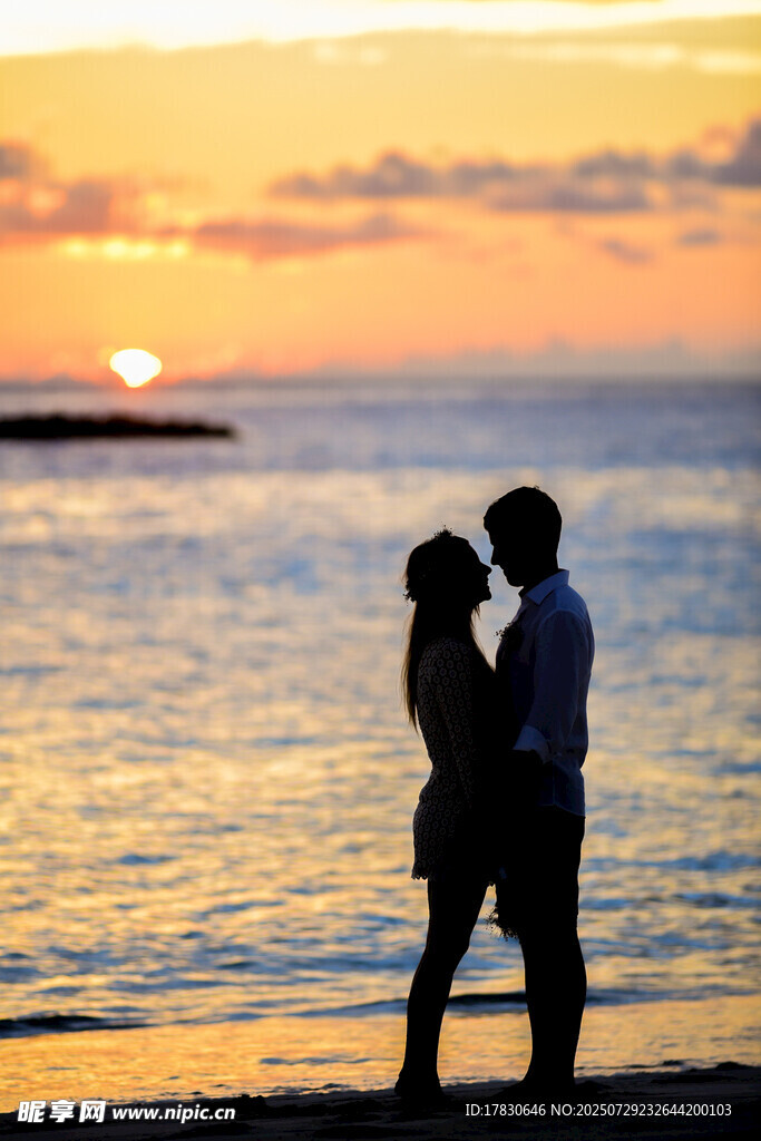 夕阳下海边的浪漫情侣