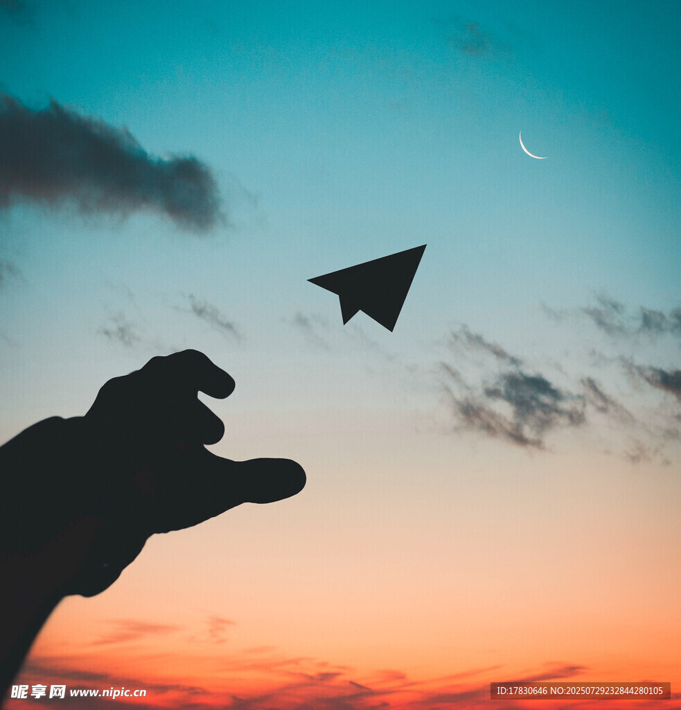 夕阳下的手放飞纸飞机