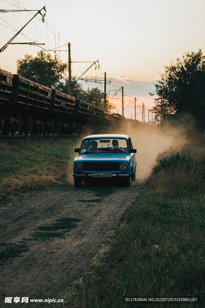 夕阳下公路上行驶的复古汽车