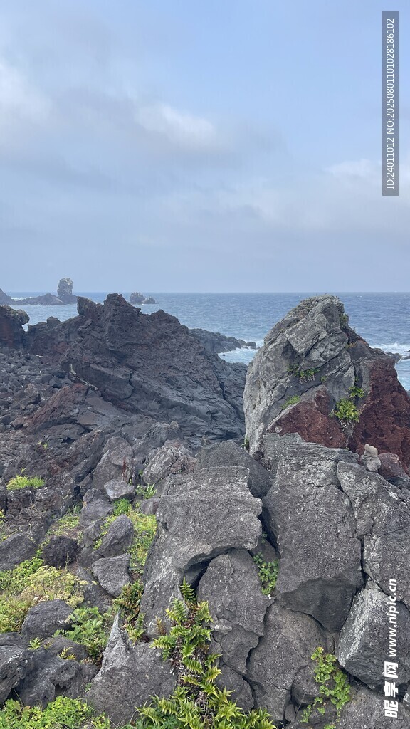 海边嶙峋岩石与远处灯塔