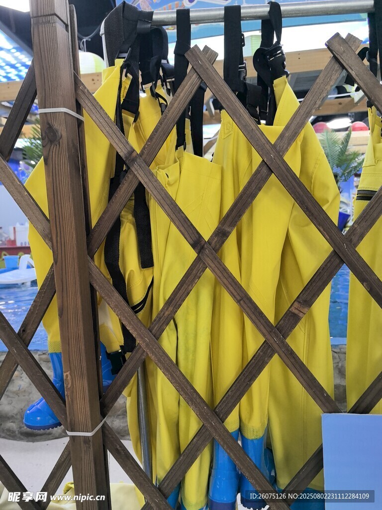 黄色雨衣挂在木质围栏上