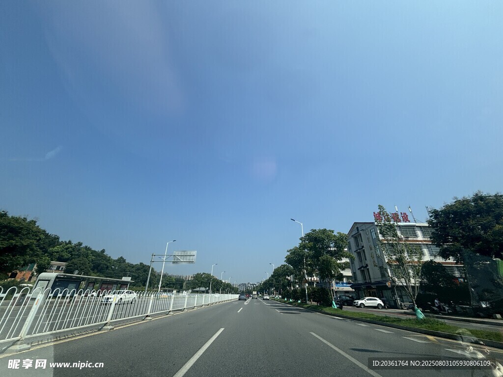 宽阔公路旁绿树蓝天相伴