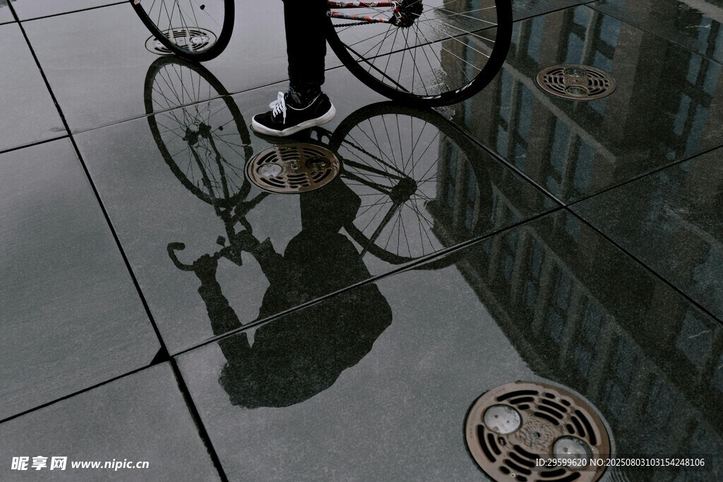 雨中骑车者与地面倒影