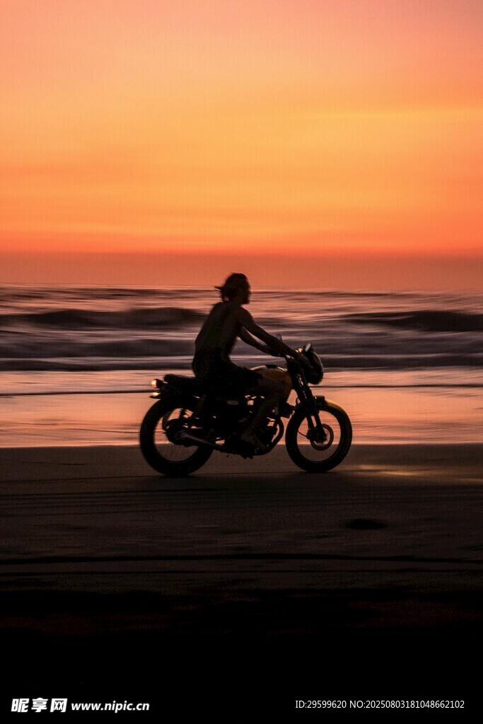 夕阳下海滩上的摩托骑行