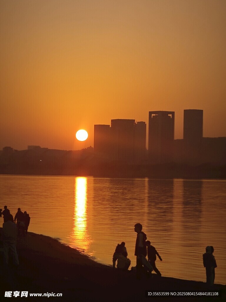 夕阳下湖畔的休闲人群