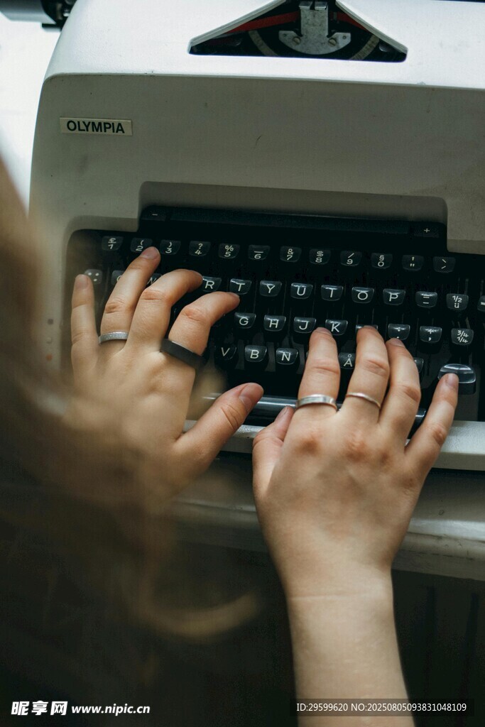 双手在老式打字机上敲击