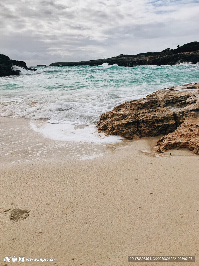 宁静沙滩与海浪中的岩石