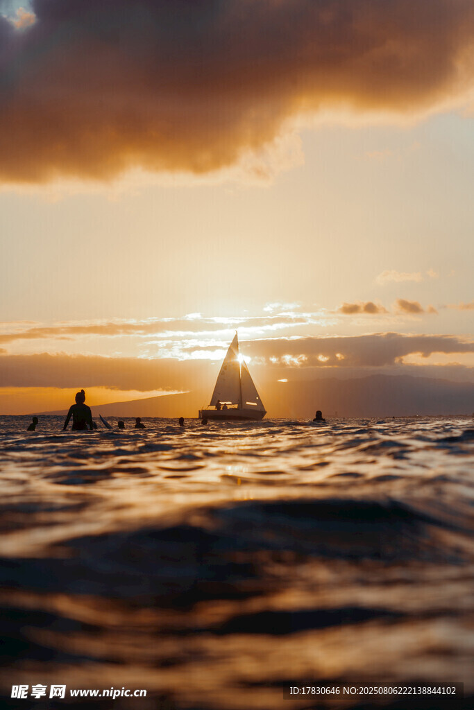 海上日落时的帆船与冲浪者