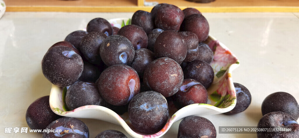 盘中紫黑色饱满的新鲜李子