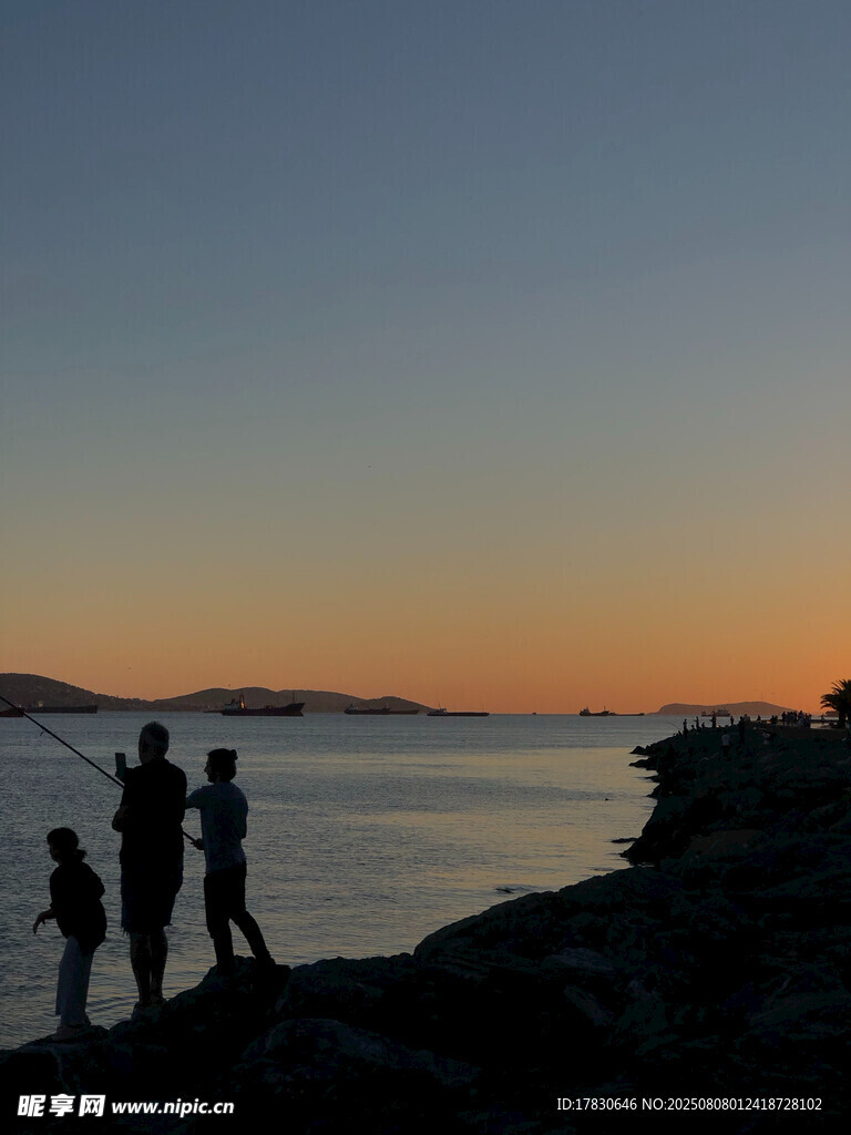 夕阳下海边的欢乐人群
