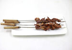 美味烤肉串摆于白盘上