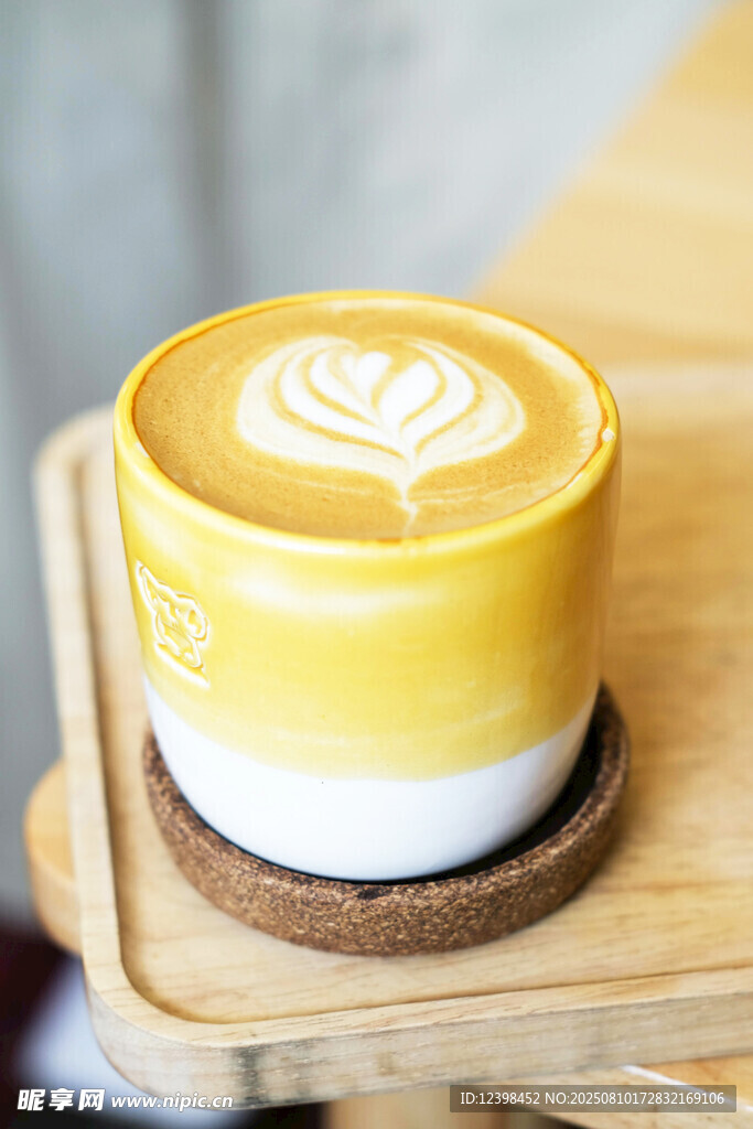 精美拉花的黄色咖啡杯