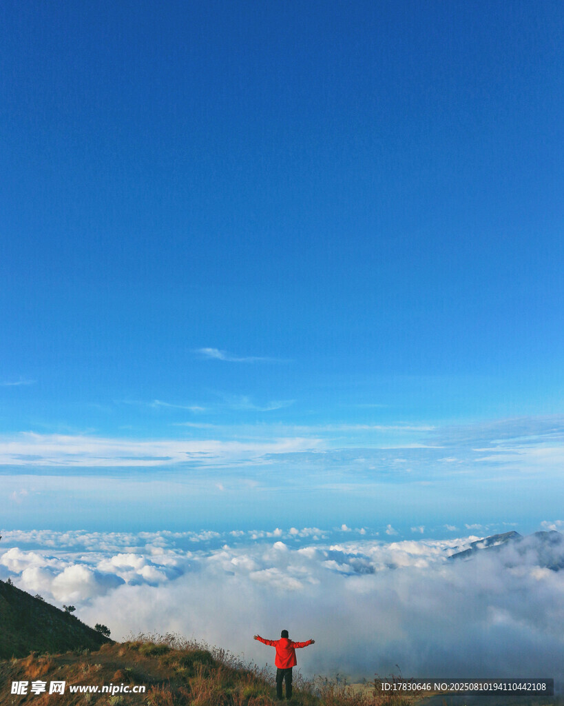 山顶红衣人俯瞰云海