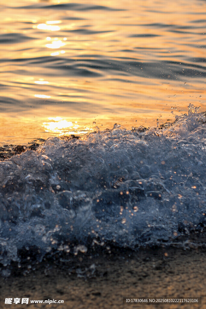 夕阳下海浪拍打沙滩