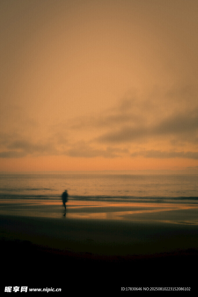 夕阳下海滩上的孤独身影