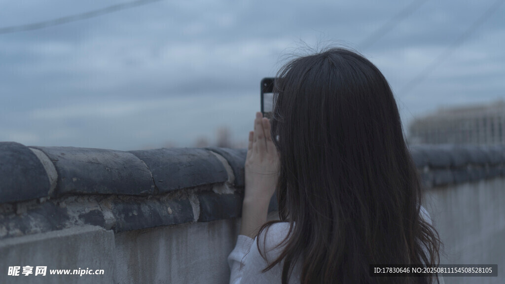 女孩楼顶用手机拍照瞬间