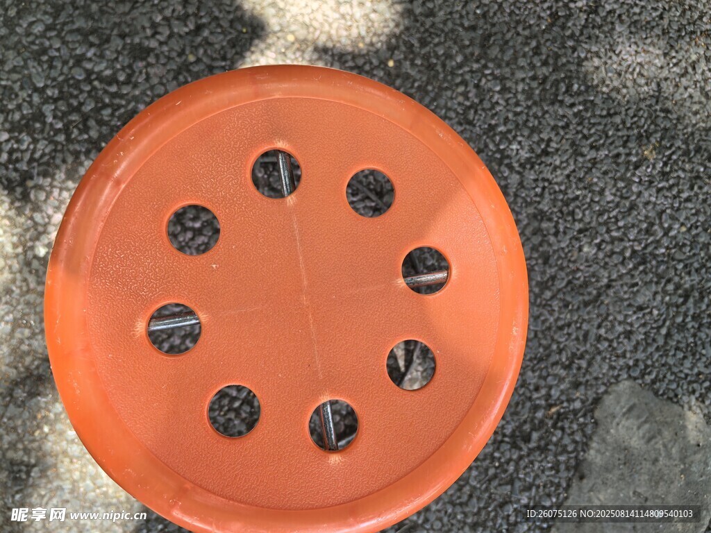 橙色带孔板凳置于地面