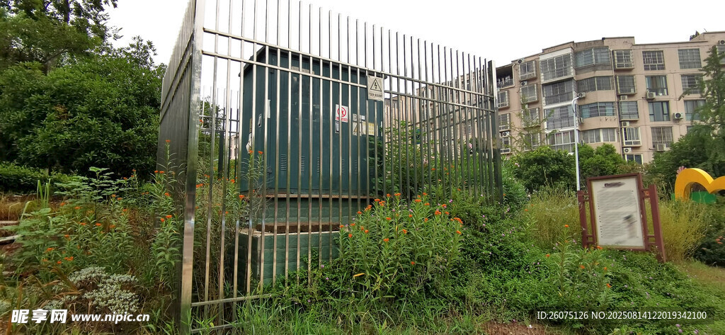 金属围栏中的绿色电箱与绿植建筑