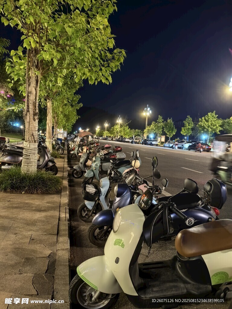 夜晚街边停放的一排电动车