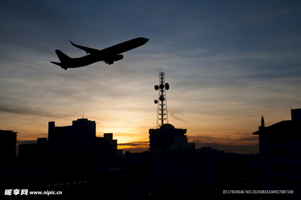 夕阳下城市上空的飞机剪影