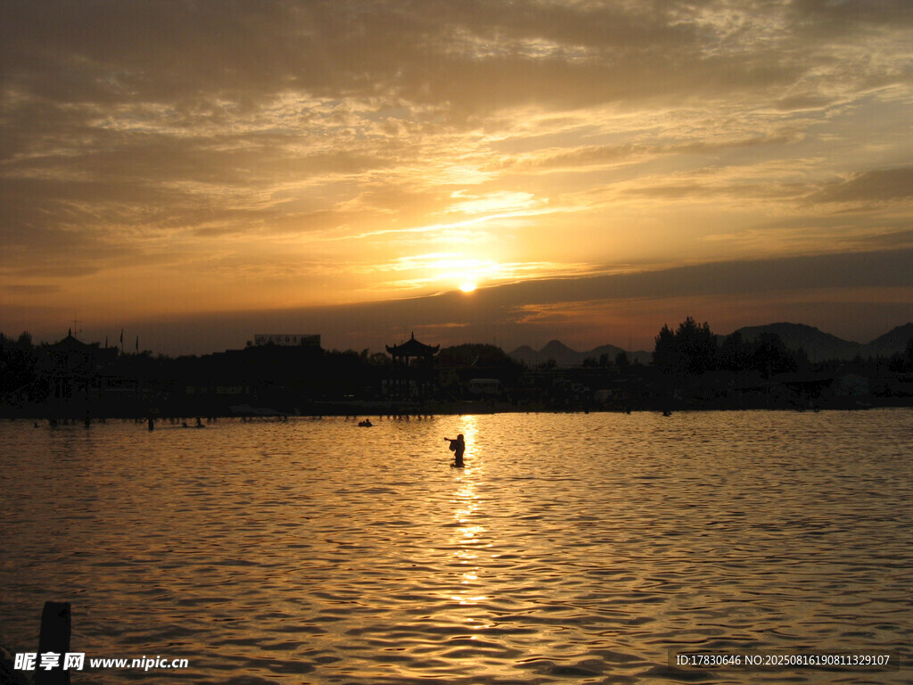 夕阳下的湖面独行者
