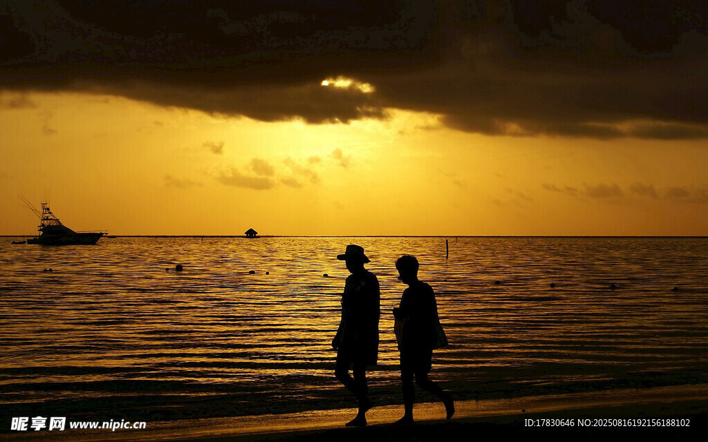 夕阳下海边漫步的两人